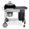 A Weber Performer Deluxe Charcoal Grill on a black background.