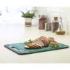 A green Cutting Board - All Purpose with a piece of meat on it.