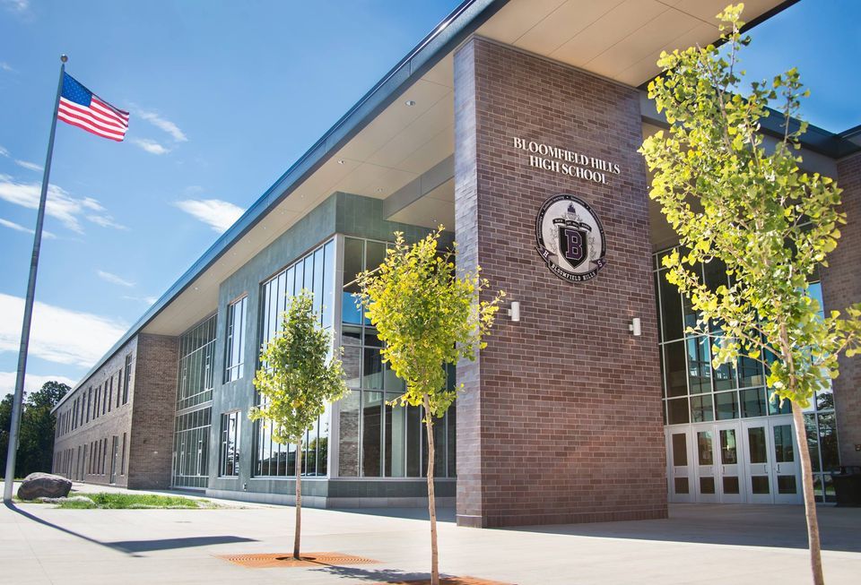 The front of a school building with trees in front of it.